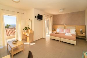 a hotel room with a bed and a balcony at Vereniki Apartments in Finikounta +37 photos
