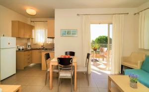 cocina y sala de estar con mesa y sillas. en Vereniki Apartments, en Finikounta