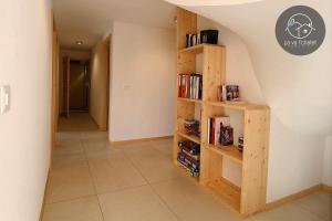 a hallway with a book shelf with books at L'Eden in Ovronnaz