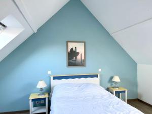 a blue bedroom with a bed with two night stands at Grand Appartement duplex vue mer in Fouesnant