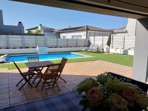 a patio with a table and chairs and a pool at LND GUEST HOUSE in Bloubergstrand