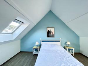 una camera da letto con un letto grande con un soffitto blu di Grand Appartement duplex vue mer a Fouesnant