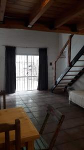 ein Wohnzimmer mit einer Treppe und einem Tisch in der Unterkunft COMPLEJO DRUMMOND en el Camino del Vino in Ciudad Lujan de Cuyo