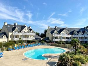 a resort with a swimming pool and some houses at Grand Appartement duplex vue mer in Fouesnant