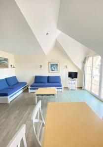 a living room with blue couches and a tv at Grand Appartement duplex vue mer in Fouesnant