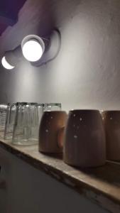 a shelf with cups and glasses on it at COMPLEJO DRUMMOND en el Camino del Vino in Ciudad Lujan de Cuyo