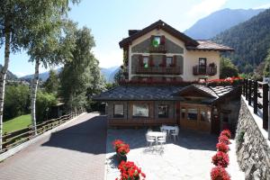 a house with a balcony and a patio with flowers at Hotel Stella Del Nord in Courmayeur
