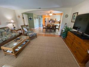 a living room with a couch and a tv at Salt water pool house near beach for monthly rental in Venice