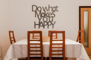 een tafel met vier stoelen en een bord met donut aantekeningen u gelukkig bij Sunshine Beach Apartment in Leiria