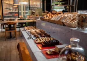 a buffet line with different types of donuts and pastries at Hotel Palermitano by DOT Boutique in Buenos Aires