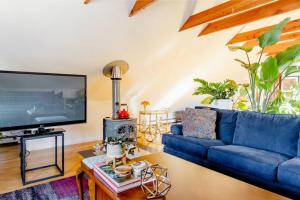 a living room with a blue couch and a tv at Urban Oasis in Hope Village in Providence