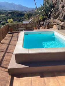 una piscina en un patio con una montaña en Villa Cueva en la naturaleza, Tecen, Valsequillo, en Valsequillo