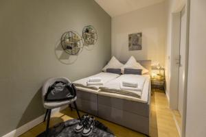 a small bedroom with a bed and a chair at The Harbour Apartment 1 in Hamburg