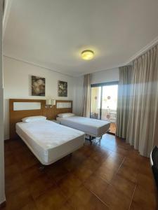 een hotelkamer met 2 bedden en een raam bij Albatros Golf & Sea View in San Miguel de Abona