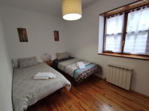 a bedroom with two beds and a window at Inmocyma La terraceta de Linsoles-Valle de Benasque in Benasque