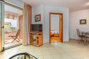 a living room with a television and a table and chairs at Cencherle in Novigrad Istria