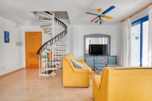 - un salon avec un canapé jaune et un escalier dans l'établissement Monduver 2006, à Piles