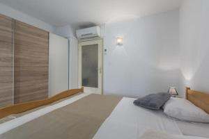 una camera bianca con un grande letto con testiera in legno di Apartment Lana a Novigrad Istria