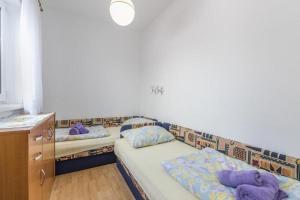 two beds in a room with purple pillows on them at Apartments Lovely Katarina in Karigador