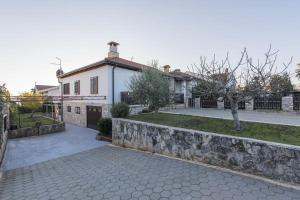 a house with a stone wall next to a driveway at Apartment Alenka in Novigrad Istria