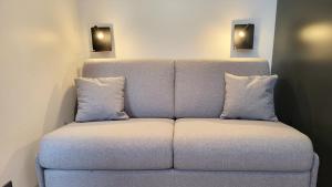 a couch with two pillows on it in a room at Star Champs-Elysées in Paris