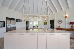 una cucina con armadi bianchi e soffitto bianco di Villa Calico a Les Bases (Marie-Galante)