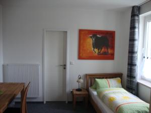 een slaapkamer met een bed en een foto van een koe bij Raffelberger Hof in Mülheim an der Ruhr