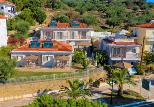 Vistas al mar de una villa con palmeras y casas en Vereniki Apartments, en Finikounta