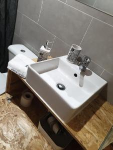 a bathroom with a white sink and a toilet at Casas de praia Sandra e Nelson in Almada