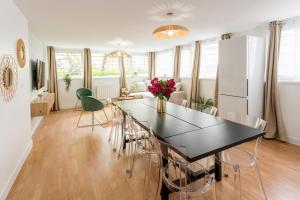 uma cozinha e sala de jantar com uma mesa preta e cadeiras em Cosy 7 Bedrooms with 3 bathrooms - Le Marais em Paris