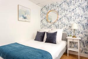 um quarto com uma cama com um cobertor azul e um espelho em Cosy 7 Bedrooms with 3 bathrooms - Le Marais em Paris