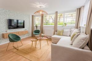 een woonkamer met een witte bank en een tv bij Cosy 7 Bedrooms with 3 bathrooms - Le Marais in Parijs