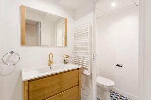 een badkamer met een wastafel, een toilet en een spiegel bij Cosy 7 Bedrooms with 3 bathrooms - Le Marais in Parijs