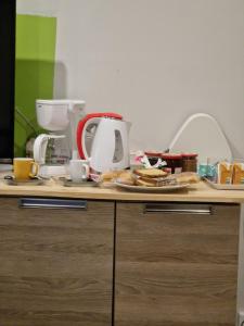 a table topped with plates of food and a coffee maker at Rêver à Béziers Centre ville et Gare in Béziers