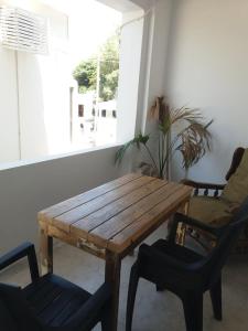 a wooden table and chairs in a room with a window at Studio George - near the beach in Matala