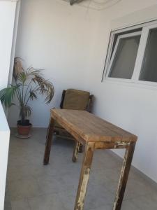 Studio George - near the beach في ماتالا: طاولة خشبية وكرسي في الغرفة