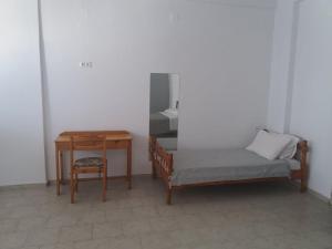 a bedroom with a bed and a table and a desk at Studio George - near the beach in Matala