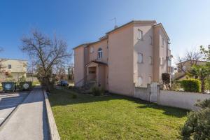 duży dom z trawnikiem obok ulicy w obiekcie Apartment Carigo w mieście Karigador