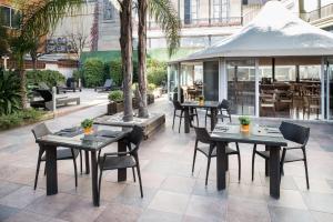 a restaurant with tables and chairs and a gazebo at Catalonia Portal de l'Angel in Barcelona