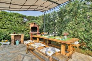 a wooden table with chairs and a grill on a patio at Villa Moira in Tar