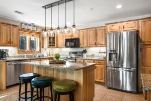 a kitchen with wooden cabinets and a stainless steel refrigerator at Condo On the Green in Arkdale
