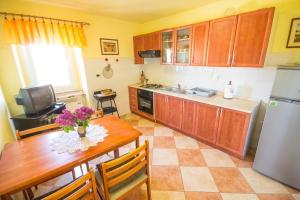 uma cozinha com uma mesa de madeira e uma cozinha com um frigorífico em Apartment Bencic em Novigrad Istria