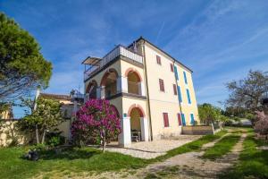 a large white house with pink flowers in front of it at Apartment Bencic in Novigrad Istria