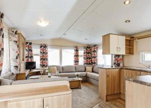 Caravana con sala de estar con sofá y cocina en Seadown Park, en Charmouth