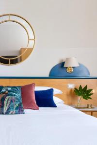 佛羅倫斯的住宿－阿拉密斯魯姆旅館，卧室配有一张带大镜子的床铺,墙上挂有镜子