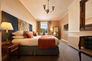 sypialnia z dużym łóżkiem i oknem w obiekcie The Royal Castle Hotel w mieście Dartmouth