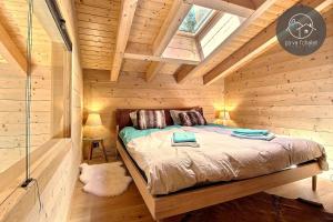 オヴロナにあるChalet de charme l'Oの木造キャビン内のベッド1台が備わるベッドルーム1室を利用します。