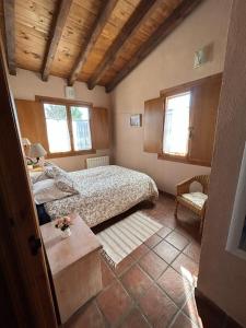 um quarto com uma cama, uma mesa e 2 janelas em Casa Rural Amarilla em Ávila