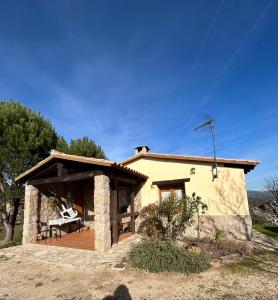 uma pequena casa com um alpendre e um deque em Casa Rural Amarilla em Ávila