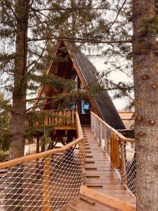 una casa en el árbol con un puente colgante entre los árboles en Xalet De Prades en Prades